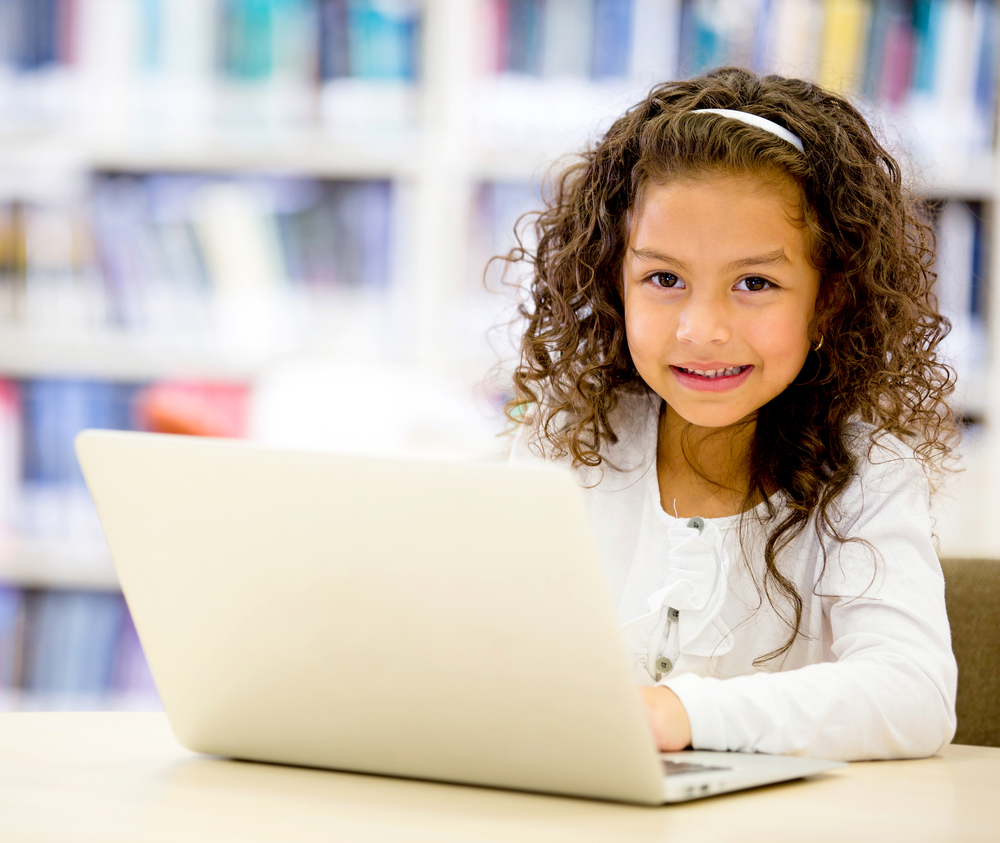 Girl using a laptop computer at school