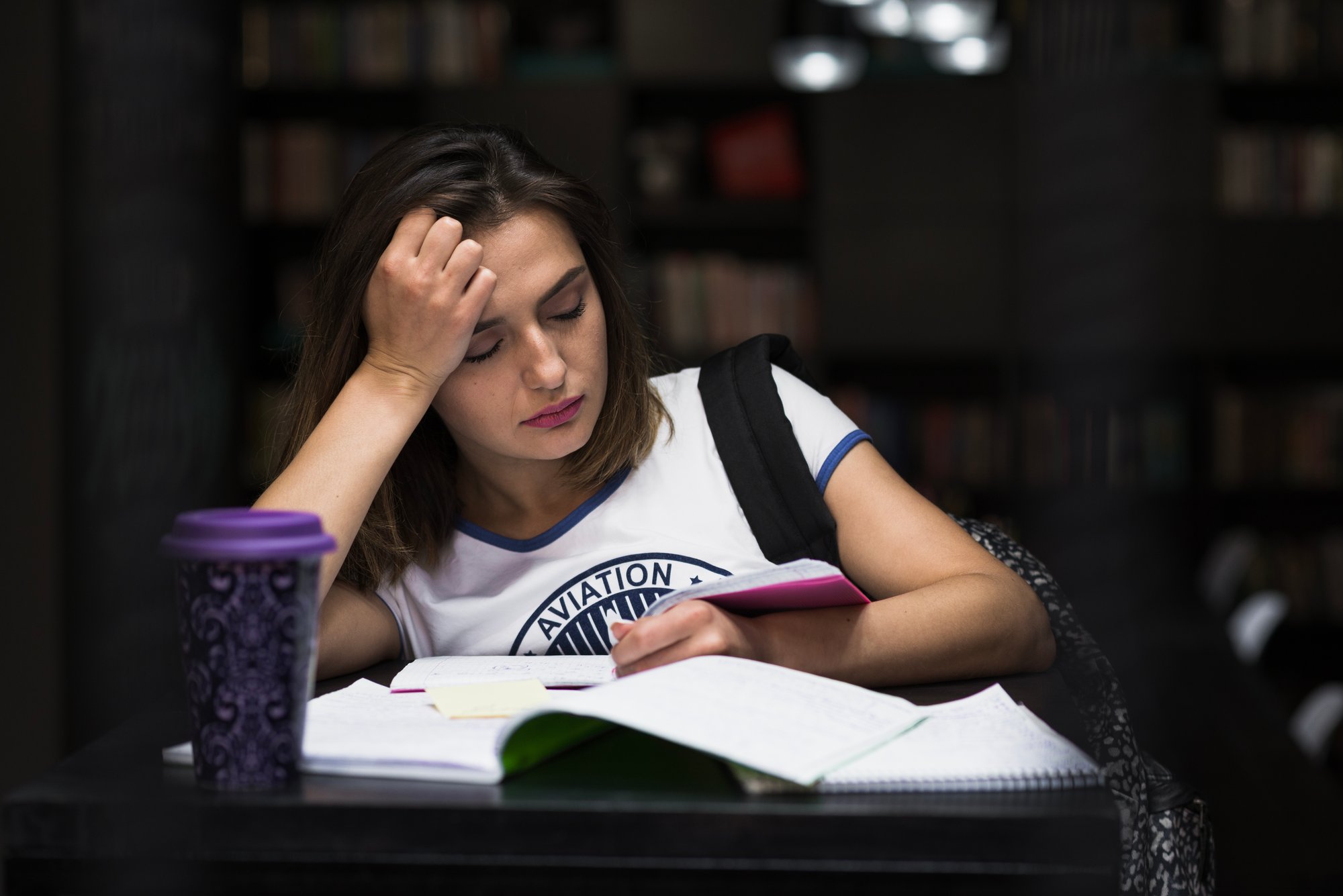 girl-sitting-table-with-notebooks-reading