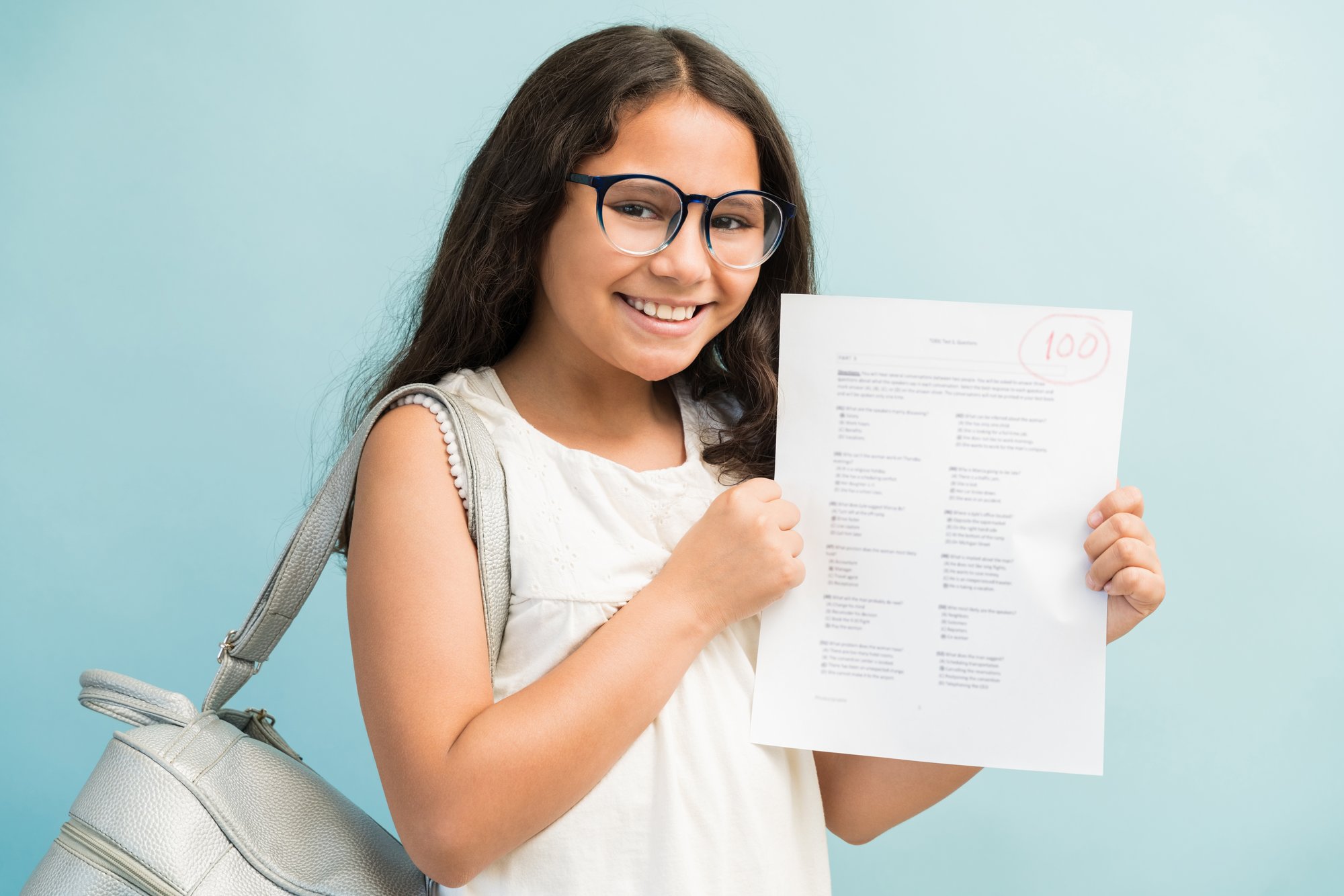 happy-latin-girl-showing-her-perfect-test-results-while-making-eye-contact-studio