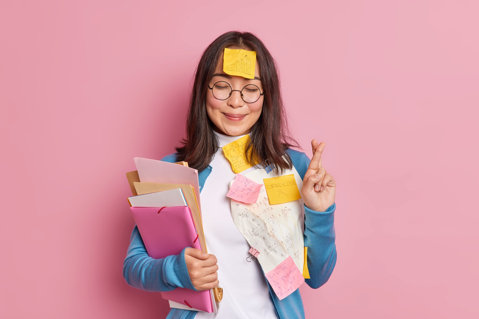 positive-schoolgirl-crosses-fingers-believes-good-luck-exam-wears-round-spectacles-stuck-with-papers-sticky-notes-written-information-remember-makes-crib-student-uses-cheat-sheets