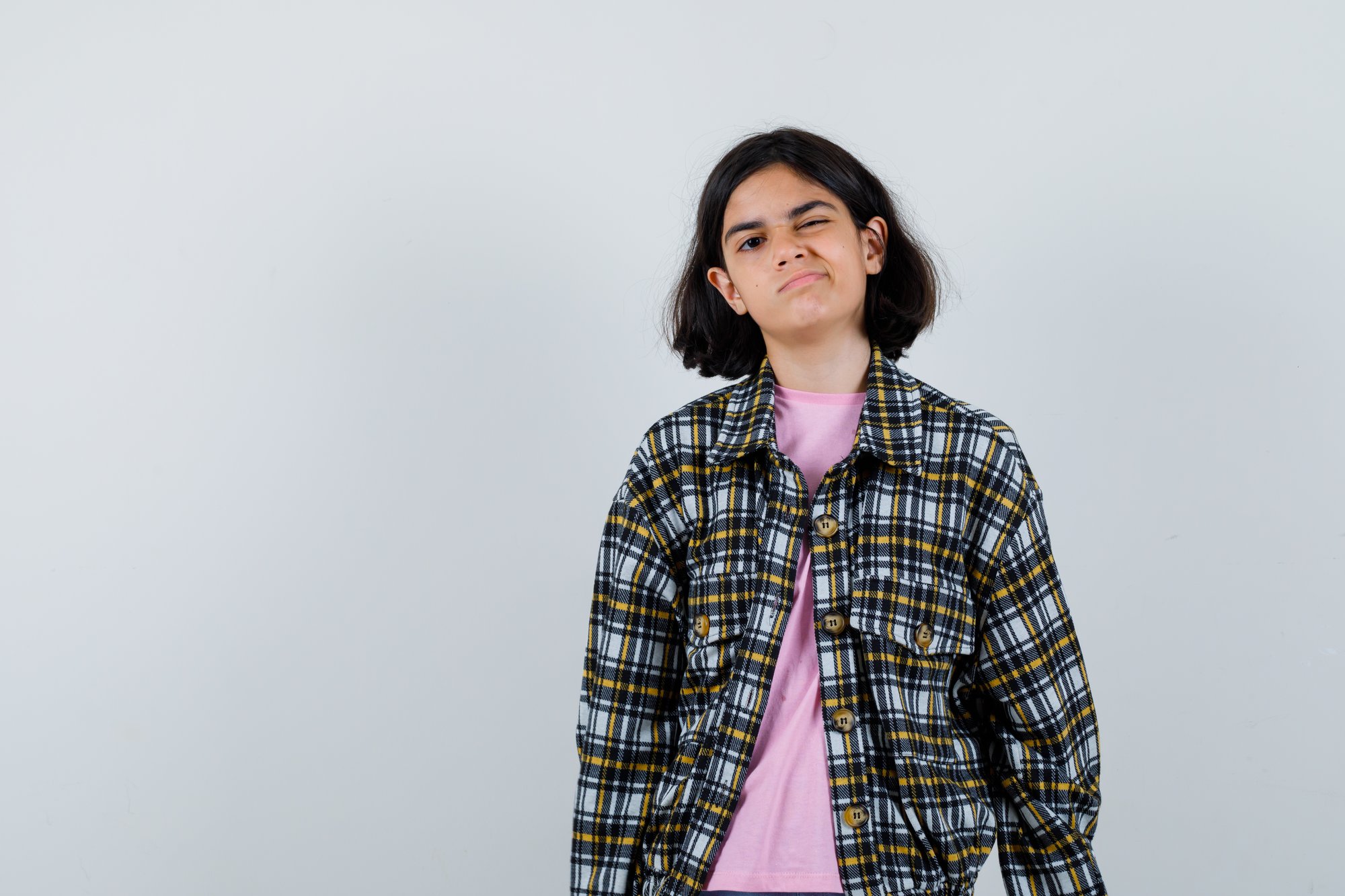 young-girl-checked-shirt-pink-t-shirt-standing-straight-winking-posing-camera-looking-pretty-front-view